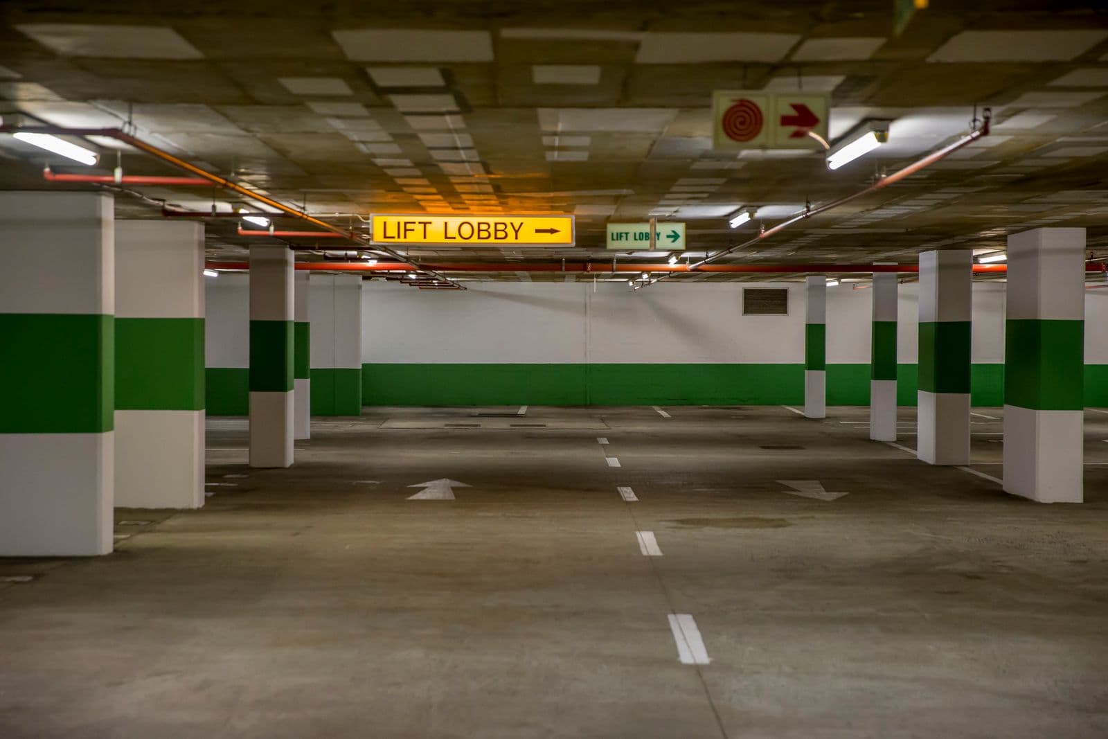 Underground parking garage with clear lift lobby signage, patrolled by MLEO-certified officers